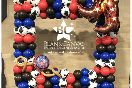 Red, blue, bown and cow print balloons making up a cowboy/country themed balloon photo frame to stand behind and take pic The front is adorned with large cowboy boot foil balloons