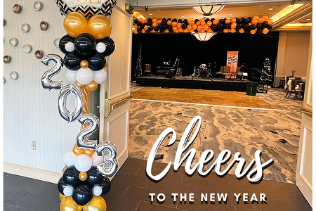 New Year's Balloon Column and Balloon Drop. Black, Gold, White, and Silver New Years column with 2023 across the front horizontally at the entry and a balloon drop on the ceiling in gold and black over the dance floor at Hilton Rialto Melbourne FL.