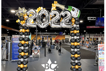 Pic of the square balloon arch we made for crunch fitness. It was striped in gold, black and silver an had a huge 2022 and champagne bottle on top with latex bubbles and a Happy New Year Balloon.