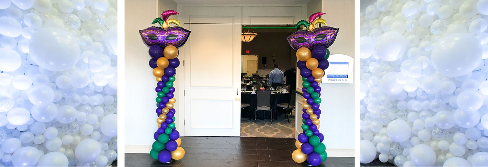 Purple, Green and Gold Graduated Balloon Columns with a spiral pattern and Mask foil balloons on top at the entry to a ballroom in Melbourne Fl